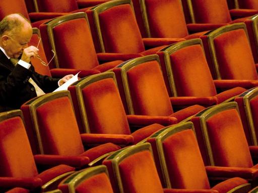 Ein Mann sitzt im Zuschauersaal der Semperoper in Dresden und wartet auf das Antrittskonzert von Christian Thielemann.