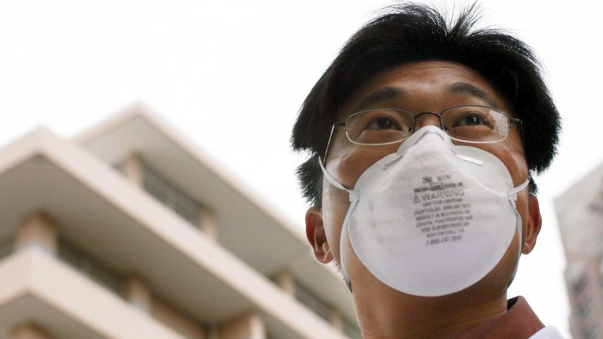 Ein Chinese steht mit einer Atemschutzmaske vor einer Sars-Quarantänestation (Archivbild) Ein Chinese steht mit einer Atemschutzmaske vor einer Sars-Quarantänestation (Archivbild)