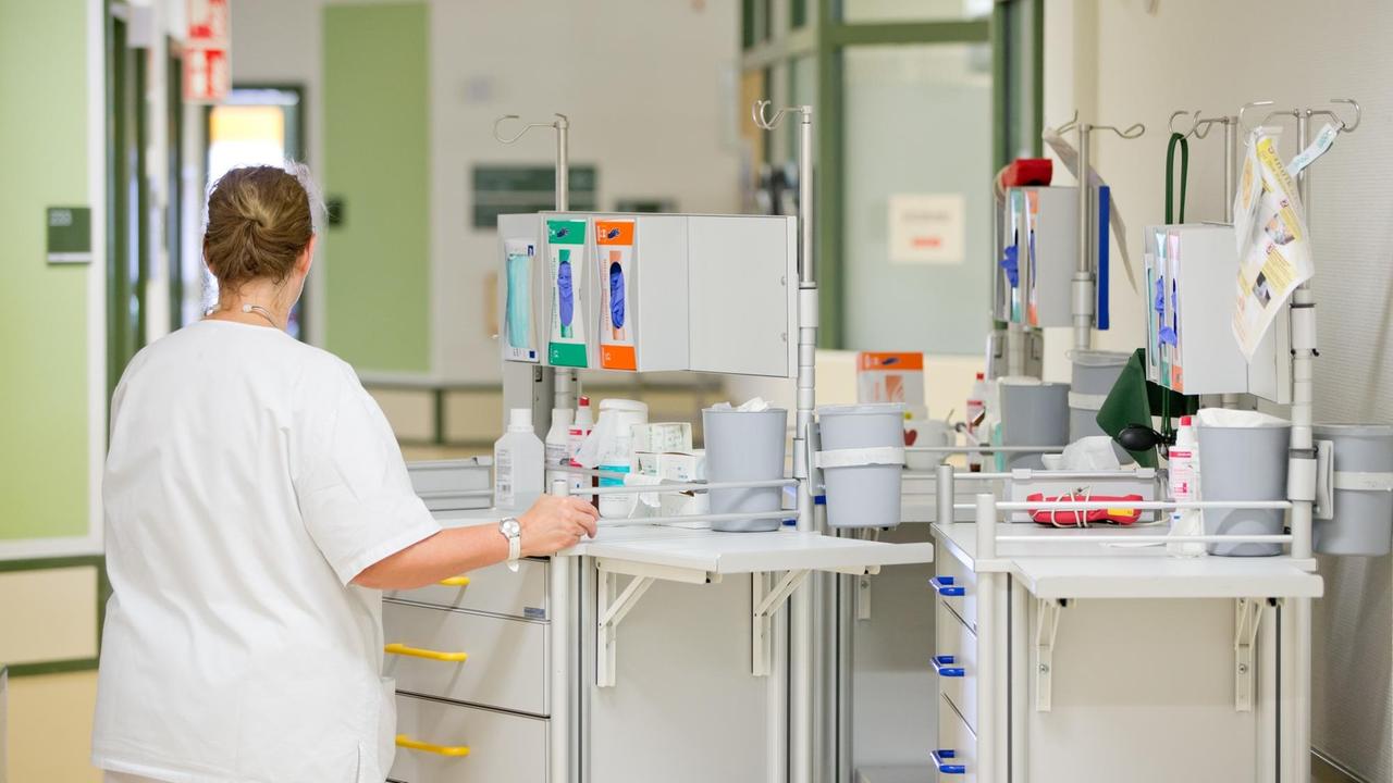 Eine Krankenpflegerin der Onkologie steht am im Flur der Station an einem Pflegewagen. Eine Krankenpflegerin der Onkologie steht am im Flur der Station an einem Pflegewagen.