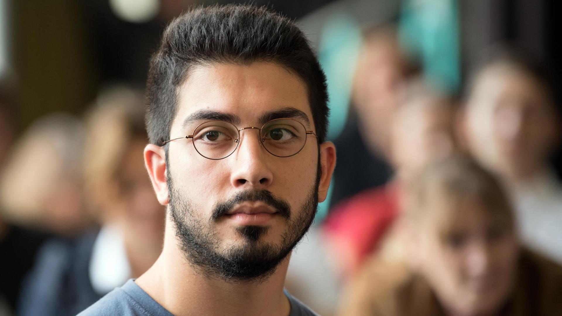 Der Antidiskriminierungs-Aktivist Ali Can schaut während einer Pressekonferenz in die Kamera. Der Antidiskriminierungs-Aktivist Ali Can schaut während einer Pressekonferenz in die Kamera.