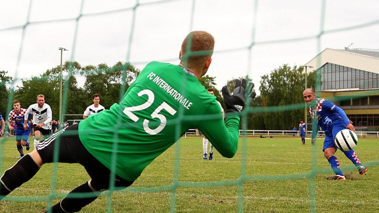 Ein Torwart mit einem Trikot von FC Internationale hält einen Ball. Ein Torwart mit einem Trikot von FC Internationale hält einen Ball.