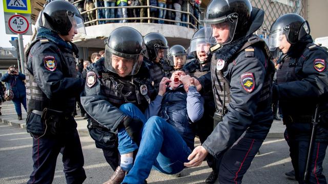 Polizisten nehmen bei nicht-genehmigten Protesten in Moskau einen Demonstranten fest.