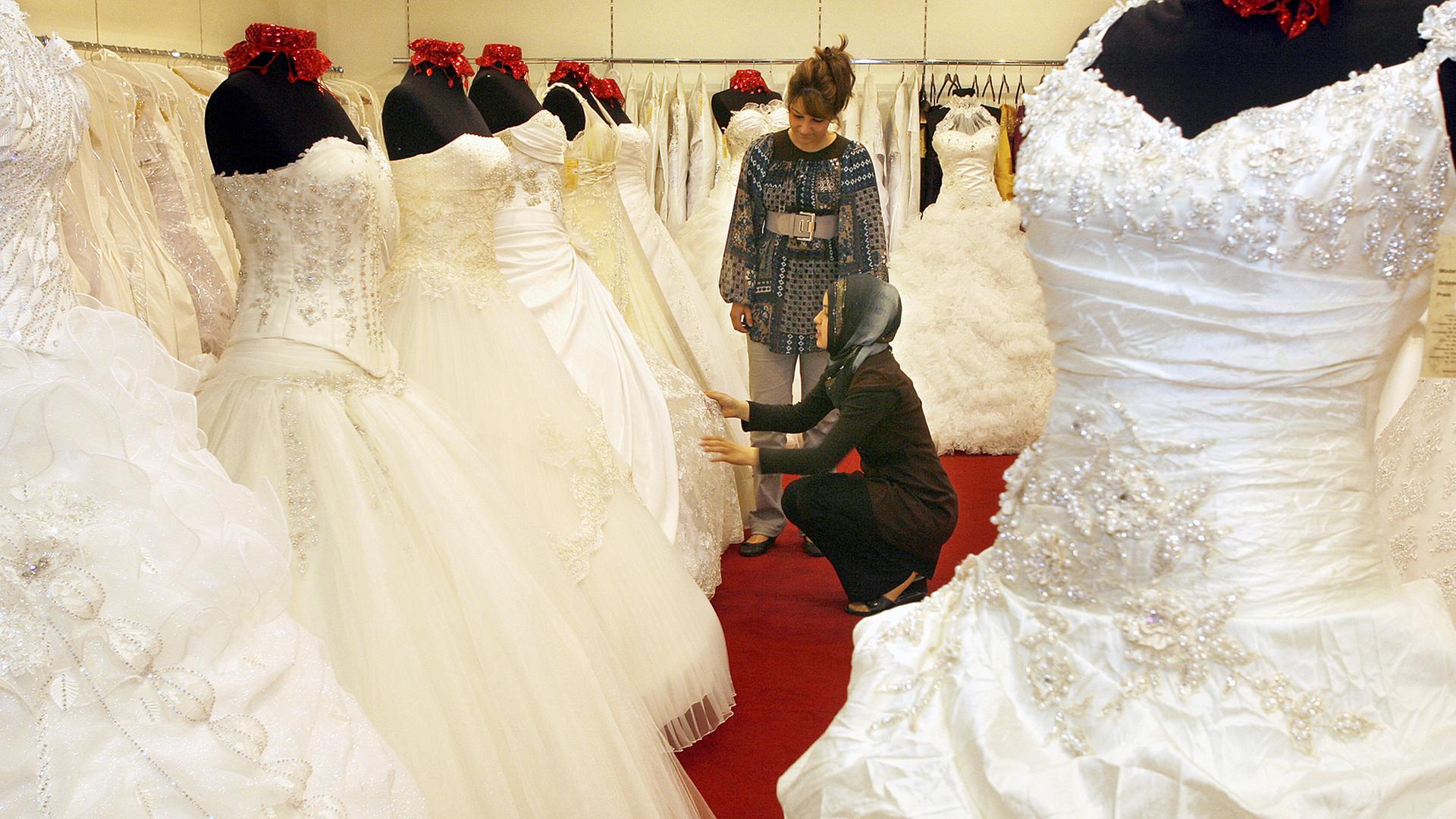Eine Verkäuferin zeigt ihrer Kundin eine Auswahl an Hochzeitskleidern im Duisburger Stadtteil Marxloh bei "Prestije". Eine Verkäuferin zeigt ihrer Kundin eine Auswahl an Hochzeitskleidern im Duisburger Stadtteil Marxloh bei "Prestije".