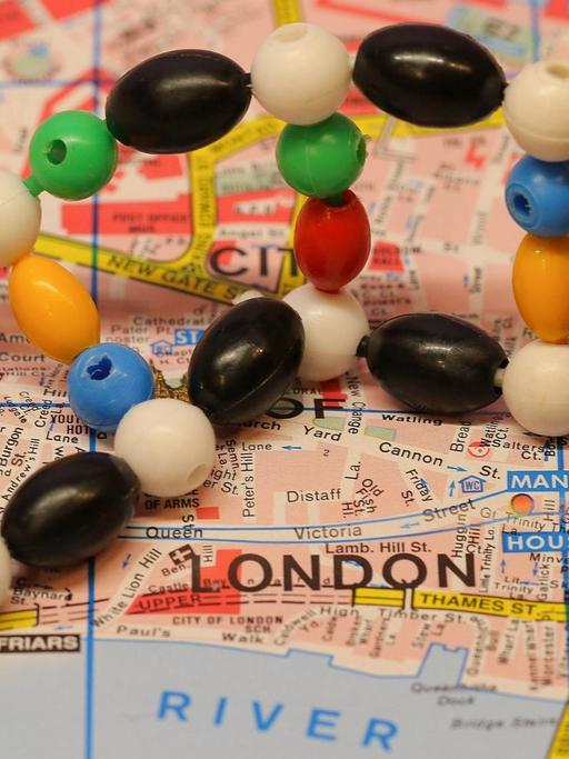 Eine DNA Doppelhelix liegt auf einem Ausschnitt einer Straßenkarte mit dem Schriftzug London.