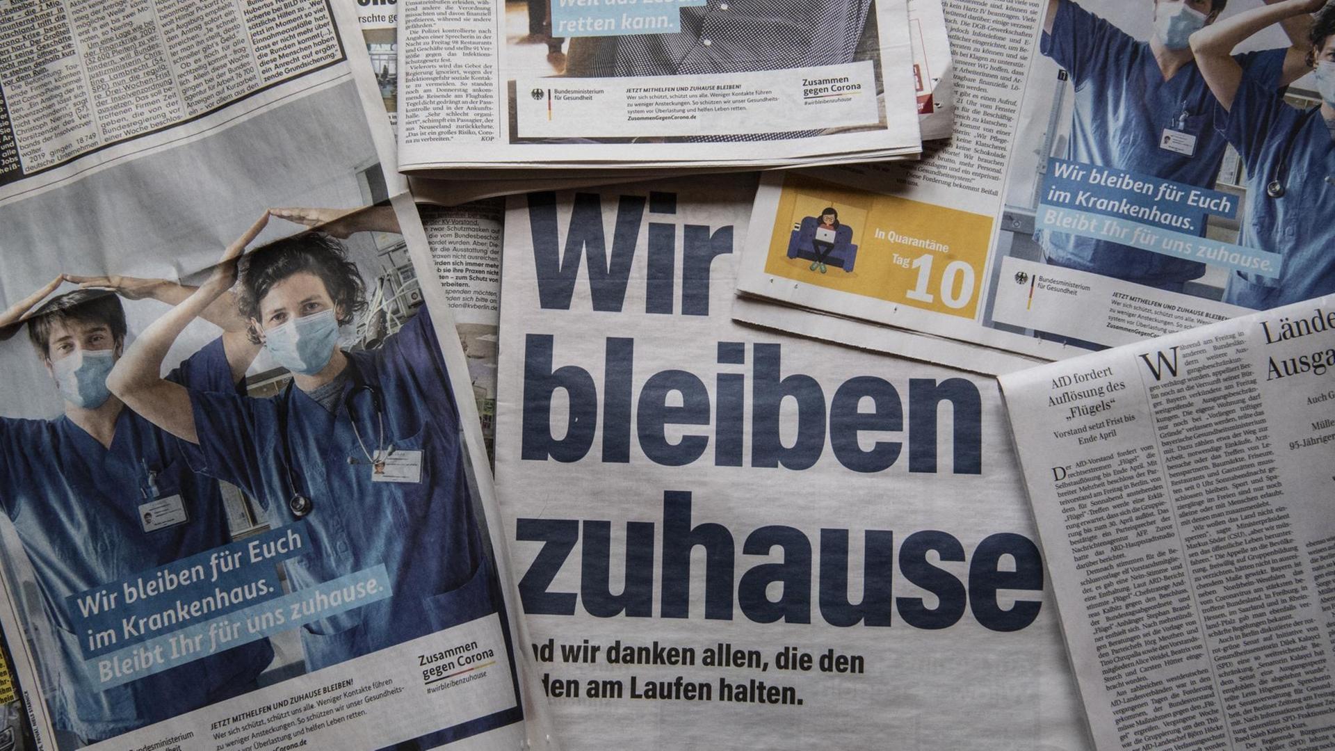 Zeitungen mit Anzeigen zur Corona-Ausbreitung unter dem Motto "Wir bleiben zuhause" Zeitungen mit Anzeigen zur Corona-Ausbreitung unter dem Motto "Wir bleiben zuhause"