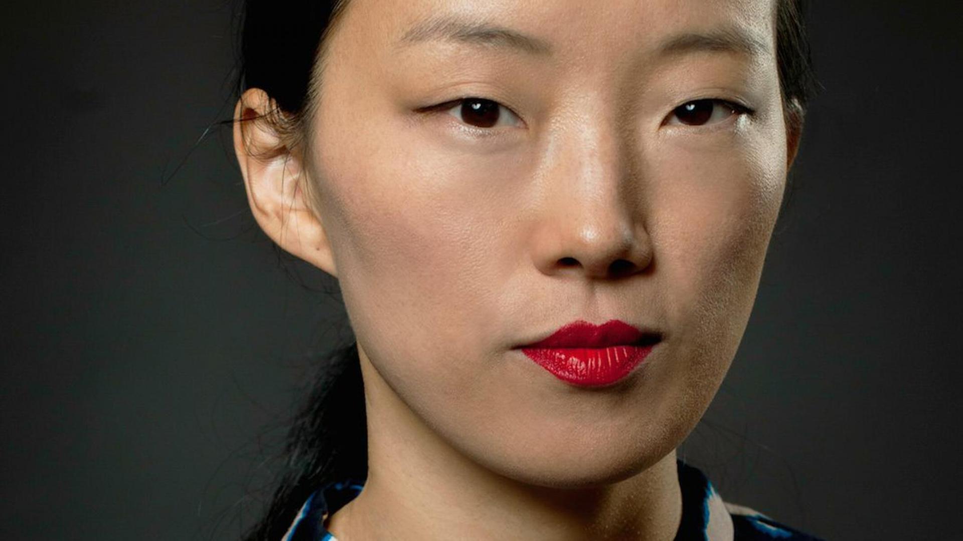 Frontaufnahme der Designerin Yang Liu, die ernst in die Kamera blickt. Frontaufnahme der Designerin Yang Liu, die ernst in die Kamera blickt.