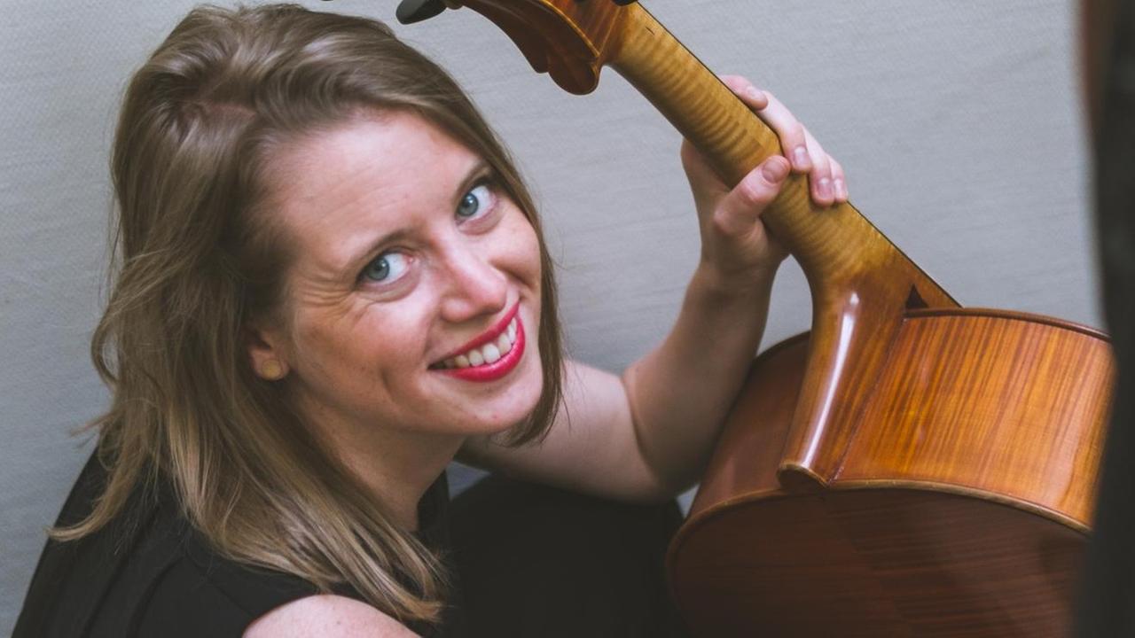 Constance Ricard mit einem Cello auf einer Treppe sitzend Constance Ricard mit einem Cello auf einer Treppe sitzend