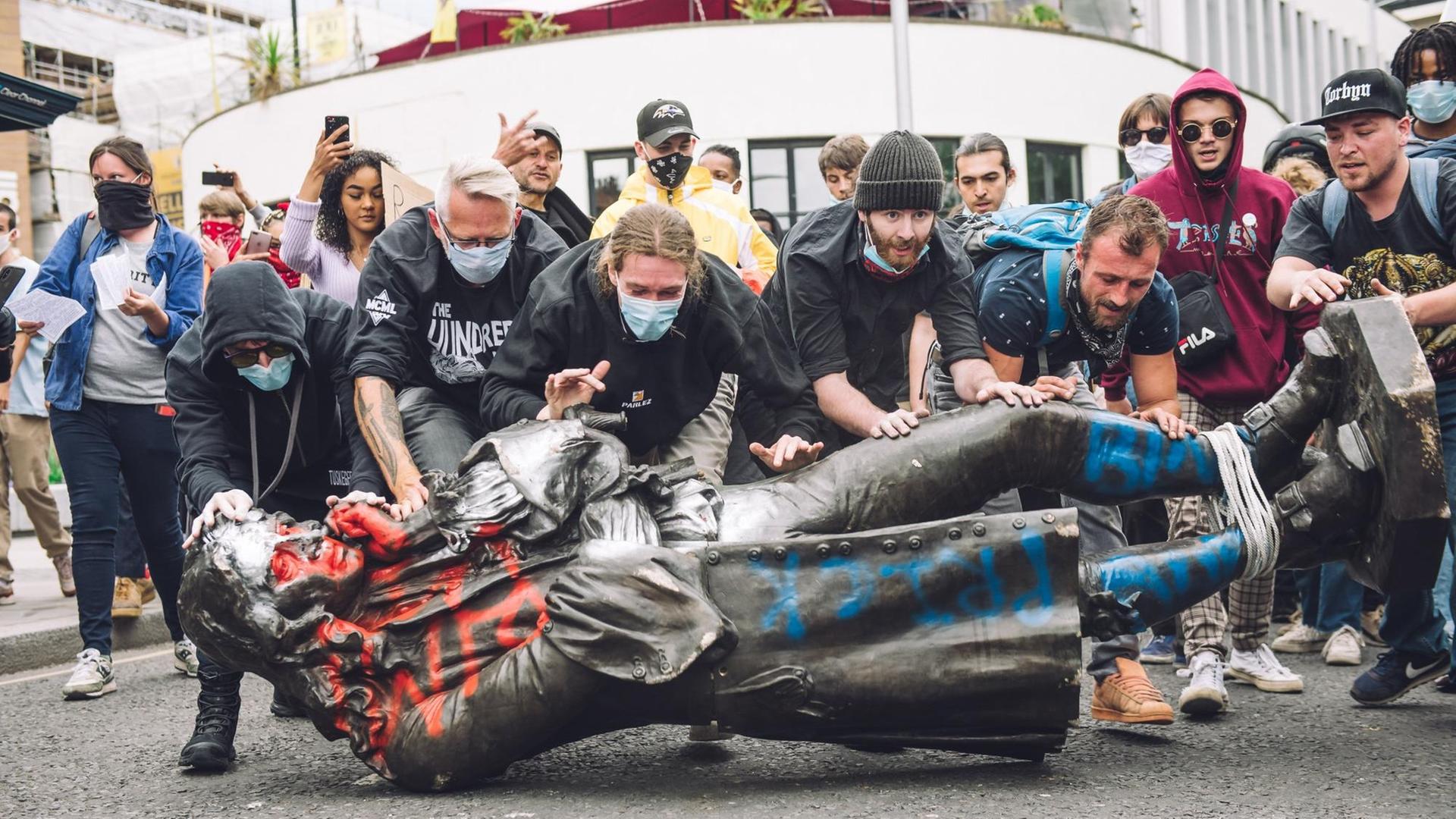 Demonstranten transportieren die Statue gemeinsam durch Bristol. Demonstranten transportieren die Statue gemeinsam durch Bristol.