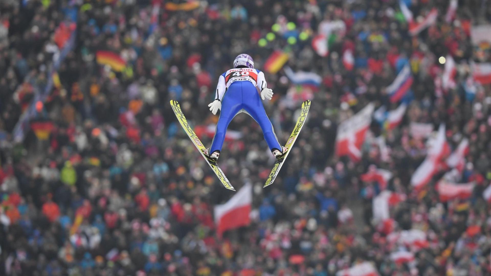 Andreas Wellinger springt von der Großschanze in Willingen (Hessen). Im Hintergrund ist das Publikum zu sehen.