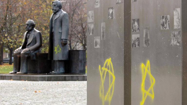 Zwei gelbe Davidsterne sind an eine Stele am Marx-Engels-Forum in Berlin geschmiert