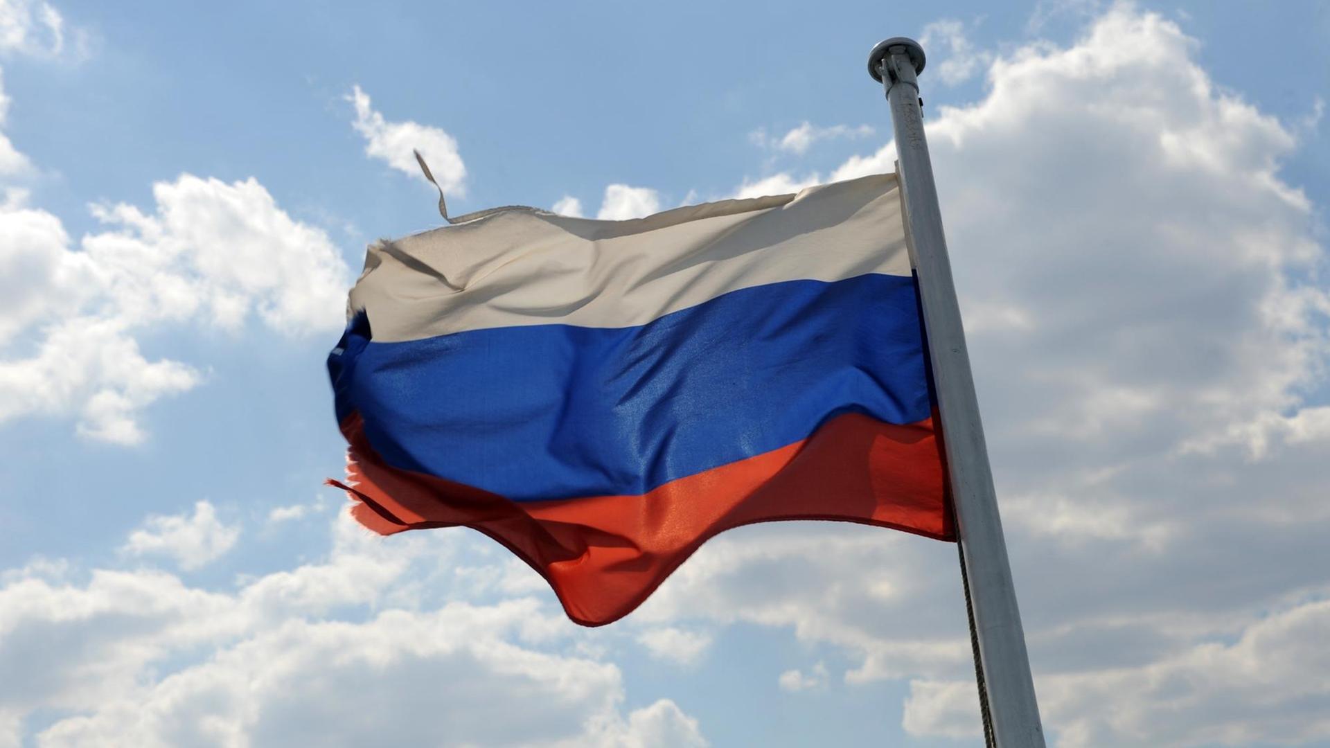 Eine leicht zerzauste russische Fahne weht in Wolgograd vor einem heiteren HImmel Eine leicht zerzauste russische Fahne weht in Wolgograd vor einem heiteren HImmel