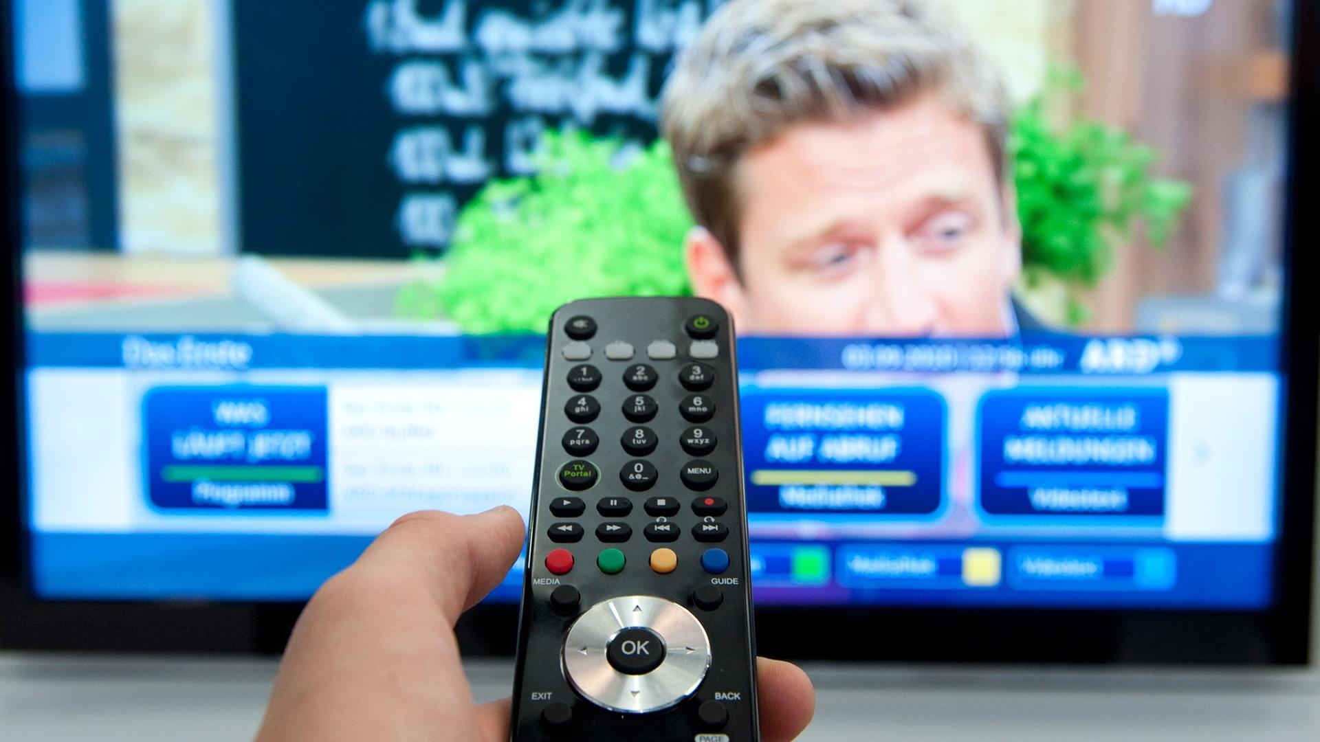 Eine Fernbedienung ist auf einen Fernseher gerichtet. Eine Fernbedienung ist auf einen Fernseher gerichtet.