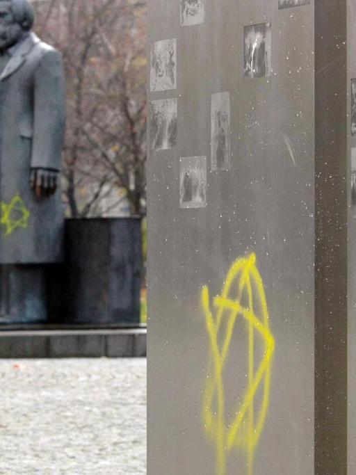 Zwei gelbe Davidsterne sind an eine Stele am Marx-Engels-Forum in Berlin geschmiert
