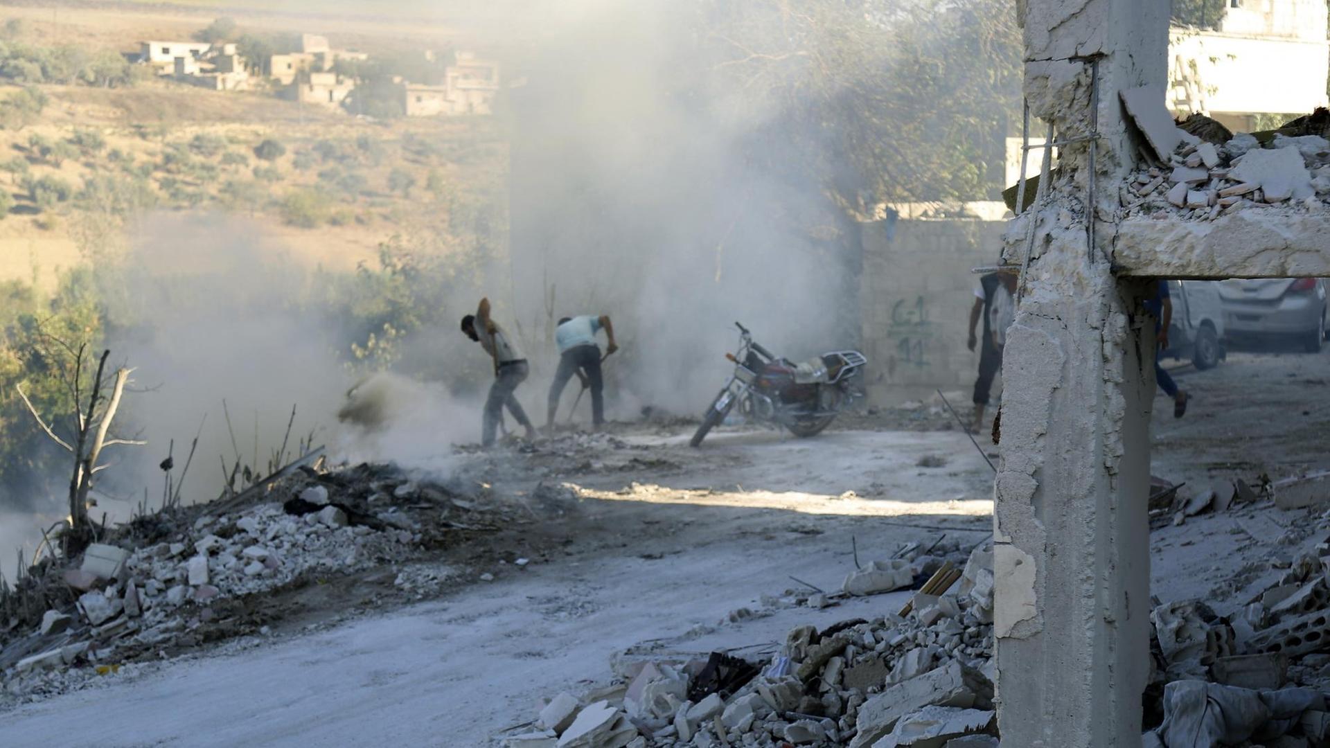 Syrer versuchen einen Brand nach einem Luftangriff im Bezirk Jisr al-Shughur in der Provinz Idlib zu löschen. Syrer versuchen einen Brand nach einem Luftangriff im Bezirk Jisr al-Shughur in der Provinz Idlib zu löschen.