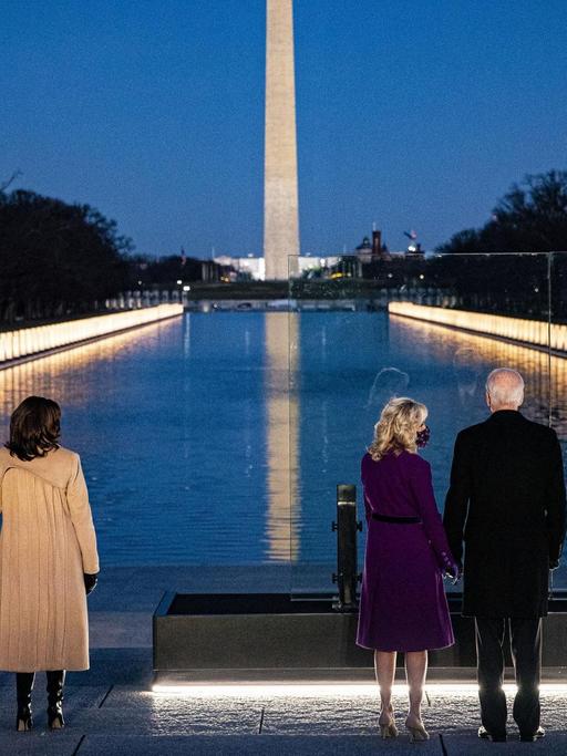 Der gewählte US-Präsident Joe Biden und seine Frau Jill und Vize-Präsidentin Kamala Harris mit ihrem Ehemann Douglas Emhoff stehen abends am von Lichtern erleuchteten Lincoln Memorial.