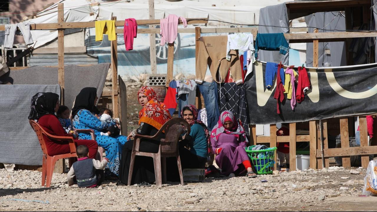 Frauen sitzen am 10.11.2015 im Libanon in der Bekaa Ebene in einem Flüchtlingslager vor ihren Behausungen. Die zumeist syrischen Flüchtlinge aus der Region Frauen sitzen am 10.11.2015 im Libanon in der Bekaa Ebene in einem Flüchtlingslager vor ihren Behausungen. Die zumeist syrischen Flüchtlinge aus der Region
