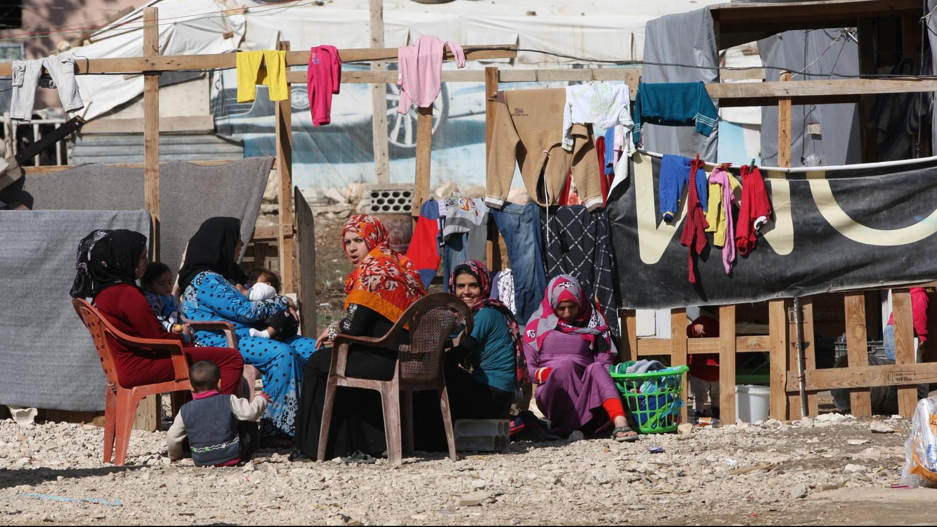 Frauen sitzen am 10.11.2015 im Libanon in der Bekaa-Ebene in einem Flüchtlingslager vor ihren Behausungen. Frauen sitzen am 10.11.2015 im Libanon in der Bekaa-Ebene in einem Flüchtlingslager vor ihren Behausungen.