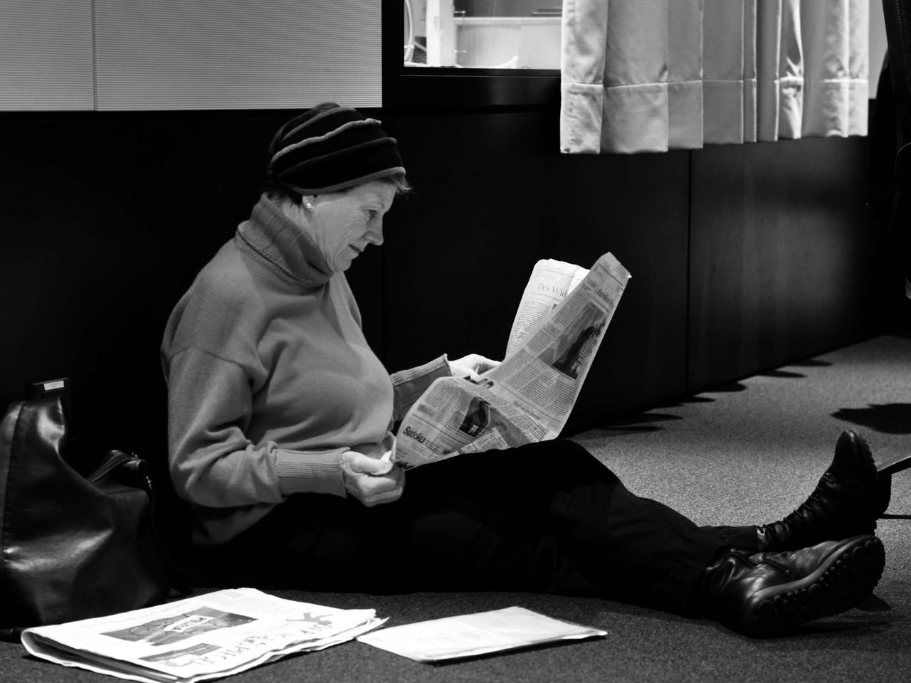 Die Schauspielerin Uta Hallant liest am Boden sitzend in einer Zeitung. Die Schauspielerin Uta Hallant liest am Boden sitzend in einer Zeitung.