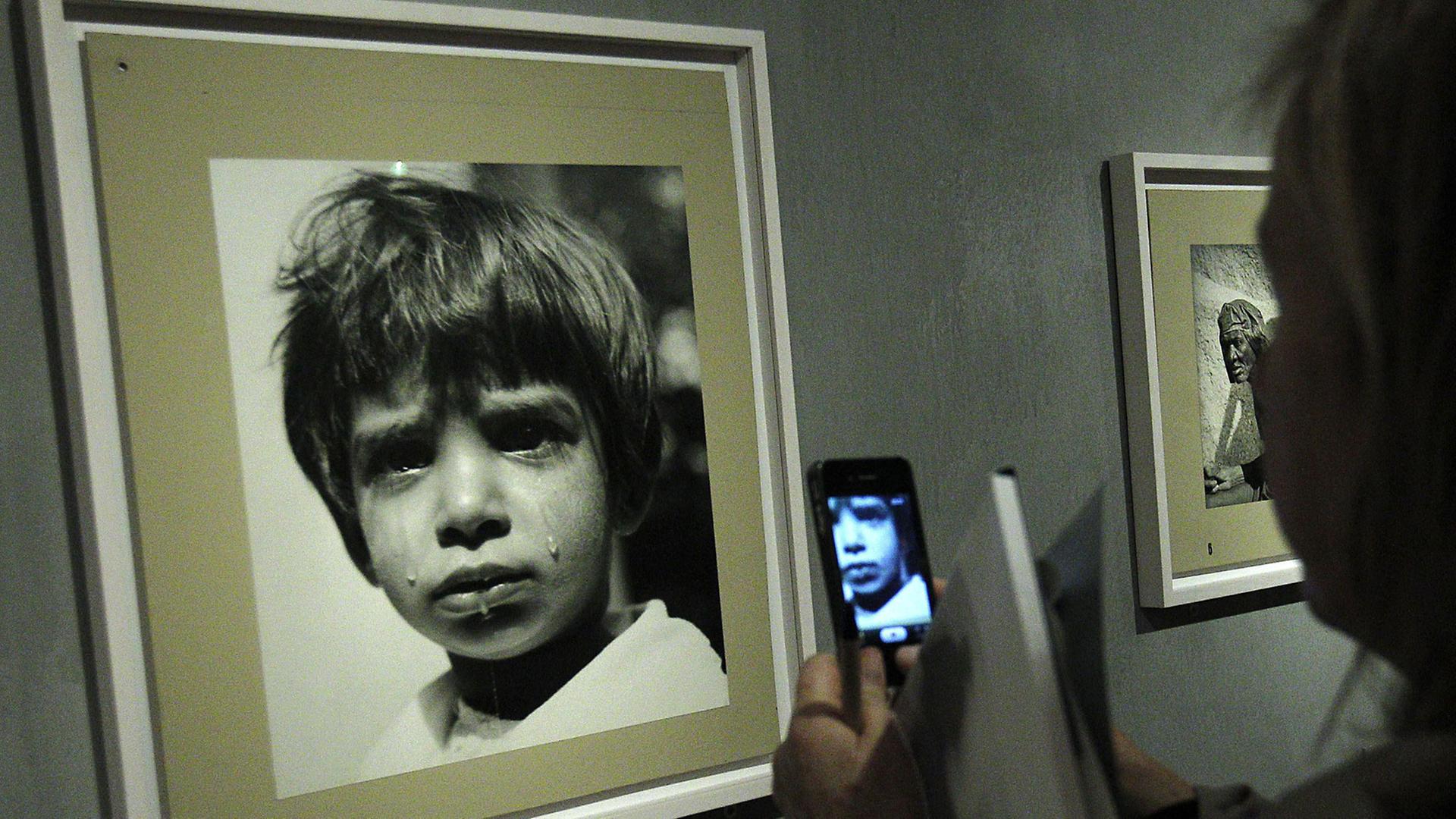 MAGNUM'S-Ausstellung von 1955: Eine Frau fotografiert mit ihrem Smartphone eine Aufnahme des Schweizer fotografen Werner Bischof, zu sehen auf einer Magnum-Ausstelung des Jahres 1955 in Madrid MAGNUM'S-Ausstellung von 1955: Eine Frau fotografiert mit ihrem Smartphone eine Aufnahme des Schweizer fotografen Werner Bischof, zu sehen auf einer Magnum-Ausstelung des Jahres 1955 in Madrid
