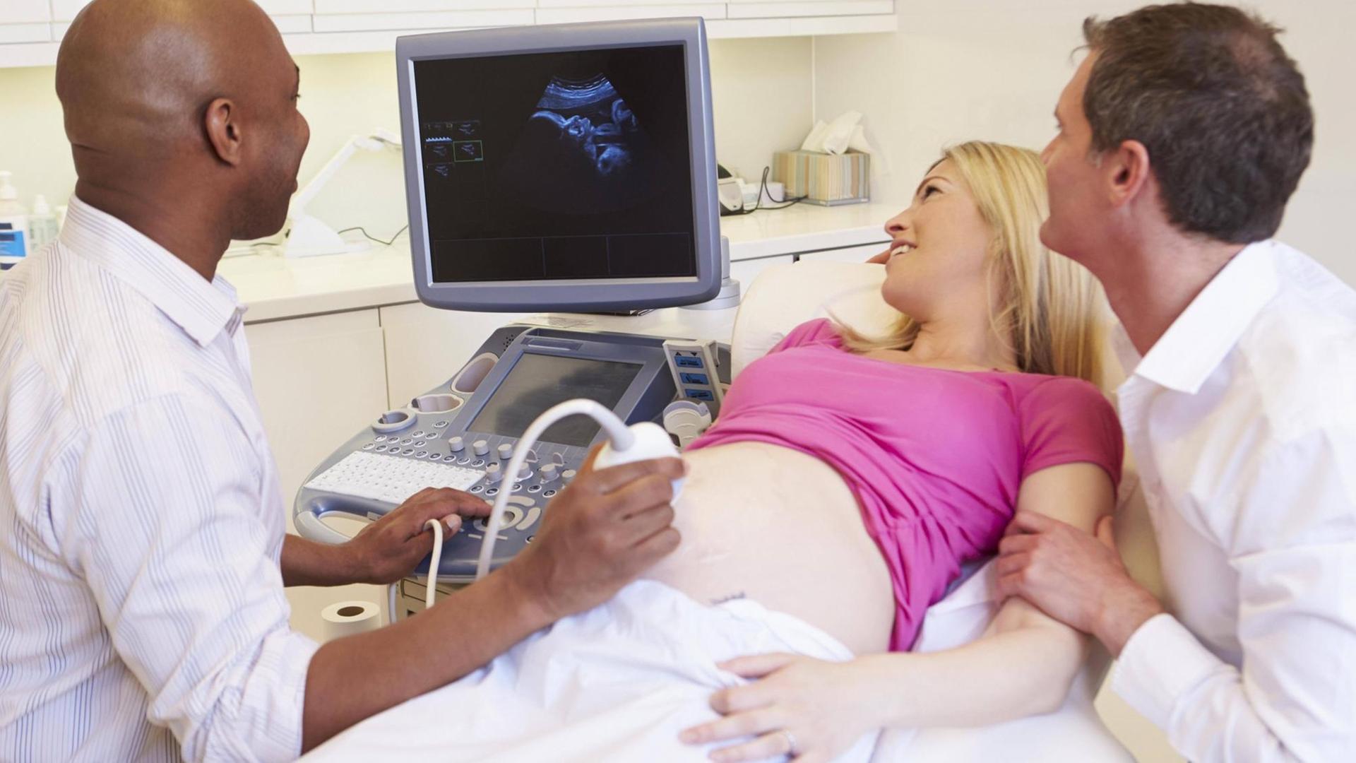 Schwangeres Paar bei der Ultraschalluntersuchung Schwangeres Paar bei der Ultraschalluntersuchung