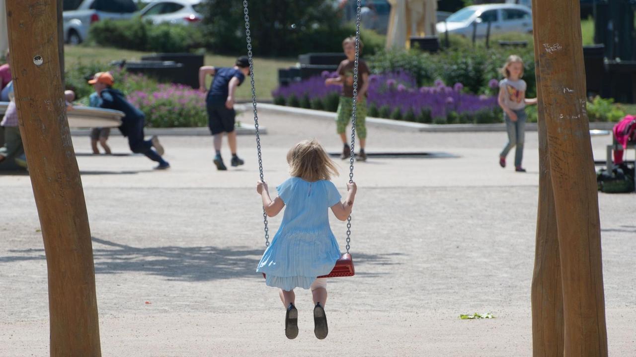Ein Mädchen sitzt auf einem Spielplatz in Erfurt (Thüringen) auf einer Schaukel. Ein Mädchen sitzt auf einem Spielplatz in Erfurt (Thüringen) auf einer Schaukel.