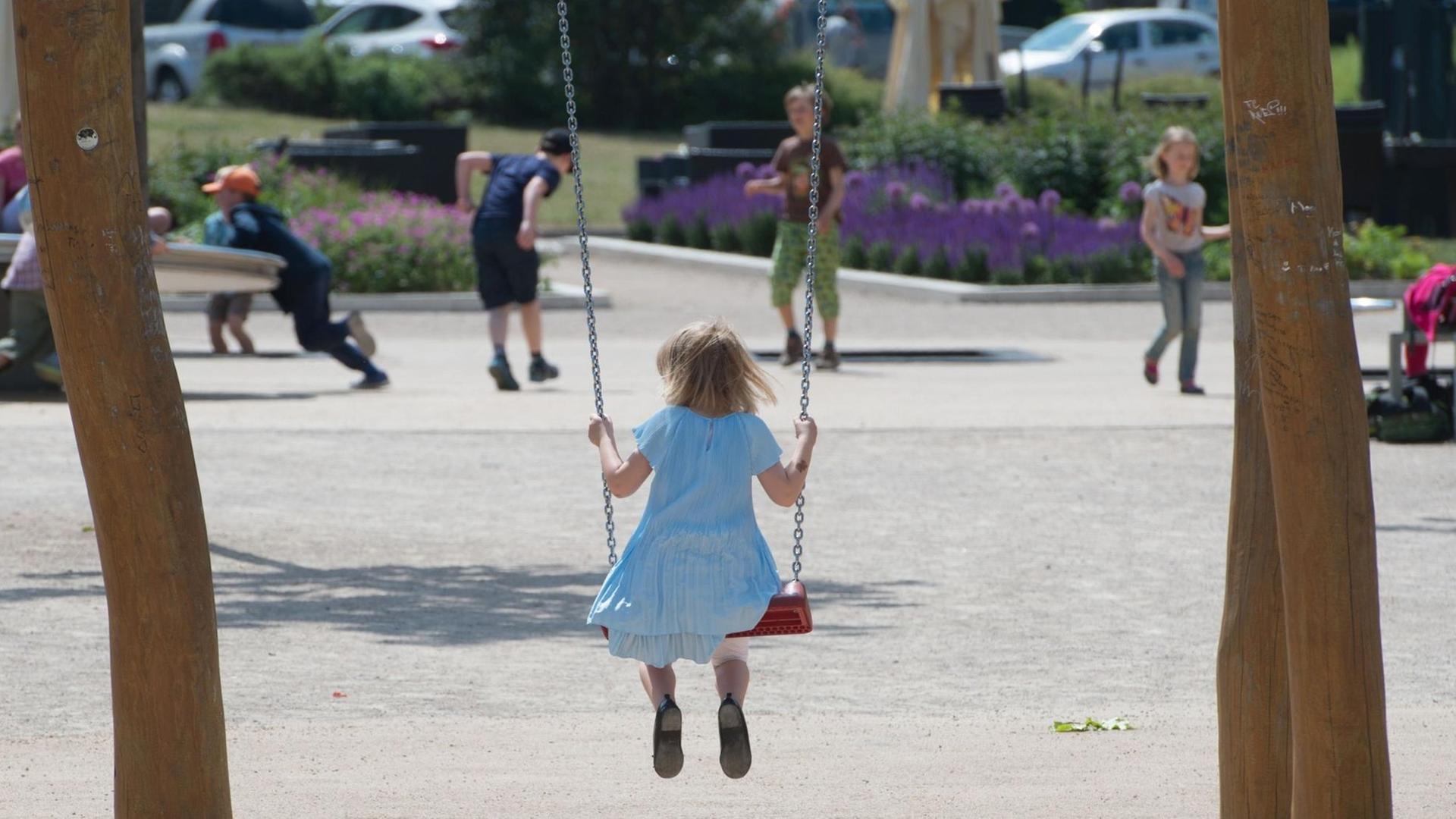 Ein Mädchen sitzt auf einem Spielplatz in Erfurt (Thüringen) auf einer Schaukel. Ein Mädchen sitzt auf einem Spielplatz in Erfurt (Thüringen) auf einer Schaukel.