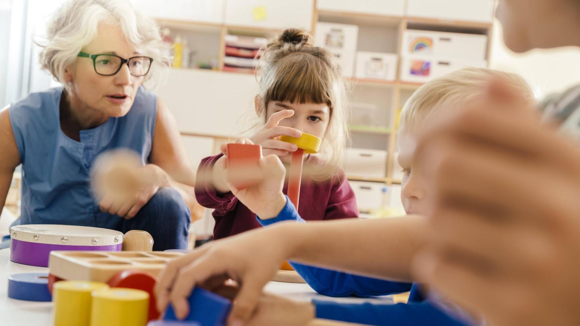 Children and teacher playing with musical instruments and toys in kindergarten. Children and teacher playing with musical instruments and toys in kindergarten.
