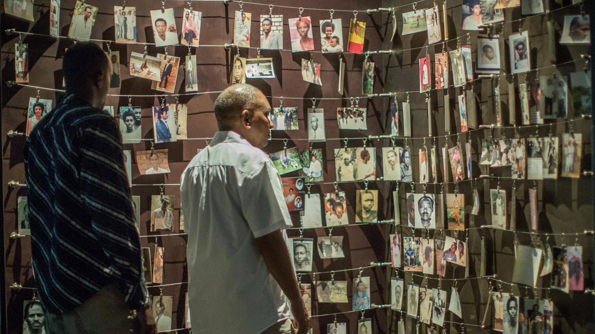 Besucher in der Gedenkstätte des Kigali Genocide Memorial Center stehen vor Fotos von während des Genozids Ermordeten Besucher in der Gedenkstätte des Kigali Genocide Memorial Center stehen vor Fotos von während des Genozids Ermordeten