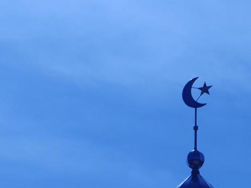 Das Minarett einer Moschee vor blauem Himmel