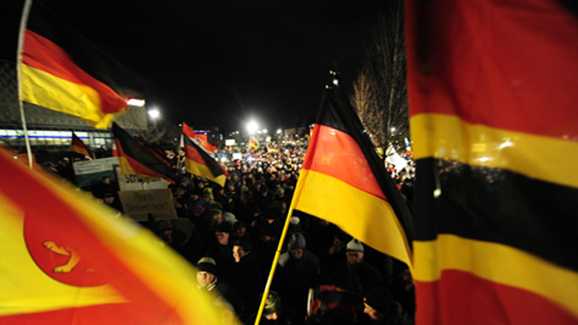 Wehende Deutschlandfahnen bei einer Pegida-Demonstration Wehende Deutschlandfahnen bei einer Pegida-Demonstration