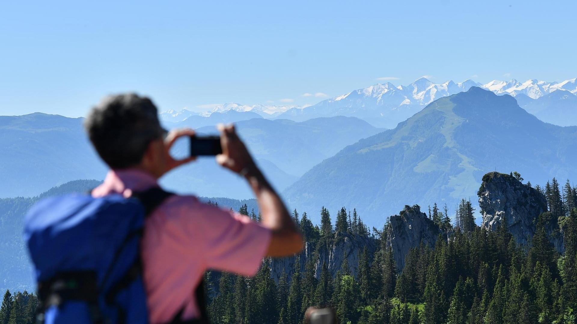 Ein Wanderer fotografiert Berge in den bayerischen Alpen Ein Wanderer fotografiert Berge in den bayerischen Alpen