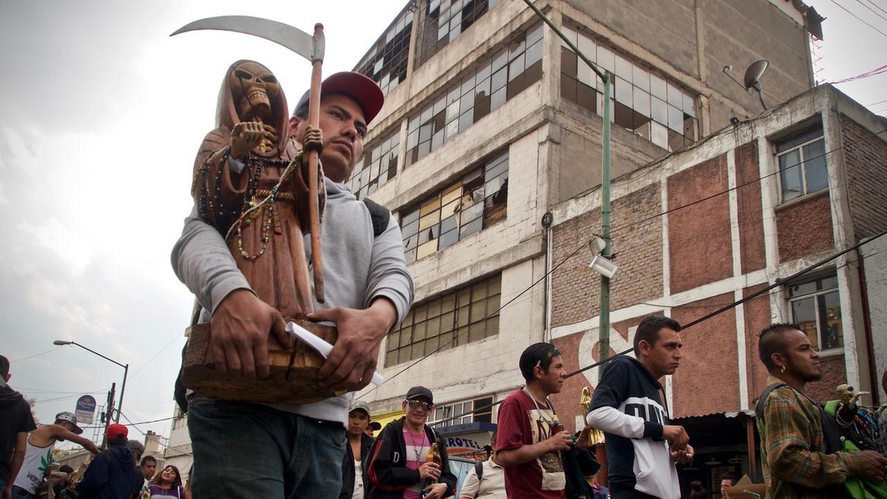 Bei einer Prozession wird eine Statue des Sensenmannes durch die Straßen getragen Bei einer Prozession wird eine Statue des Sensenmannes durch die Straßen getragen