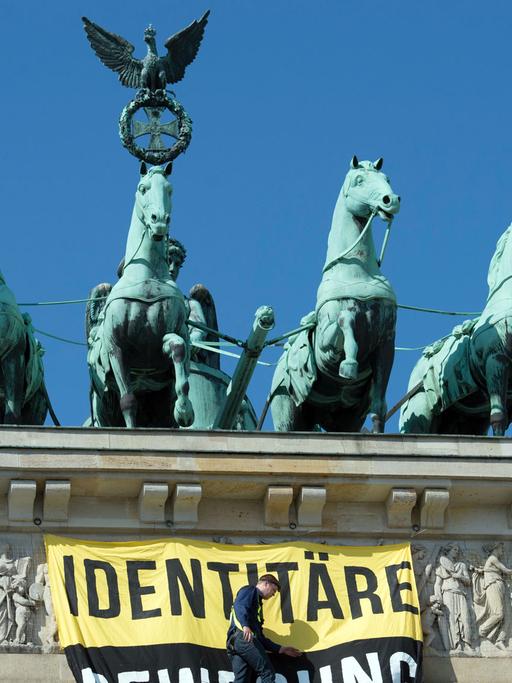 Aktivisten der "Identitären Bewegung" stehen am 27.08.2016 neben der Quadriga auf dem Brandenburger Tor. Die Gruppe wird vom Bundesamt für Verfassungsschutz beobachtet. Sie wendet sich gegen vermeintliche Überfremdung und Islamisierung.