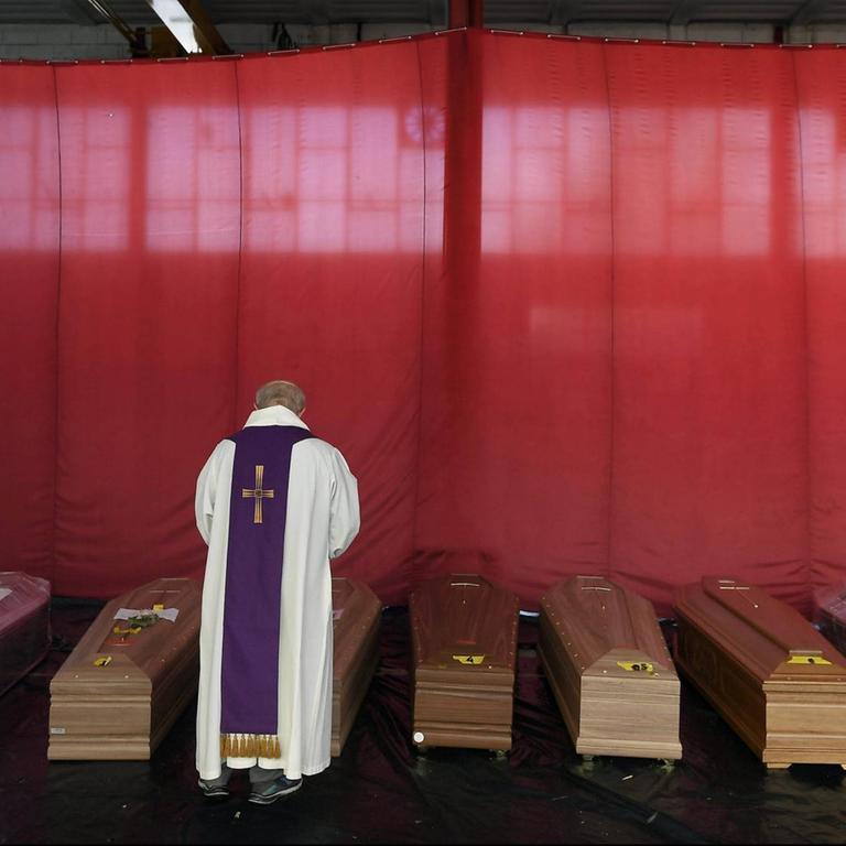 Italy, Lombardy region, Ponte San Pietro (Bergamo), April 13, 2020 : Coronavirus emergency, Covid-19. In the picture the priest blesses coffins in a deposit, in Ponte San Pietro in the province of Bergamo. They are the deaths caused by the coronavirus pandemic. Photo © Matteo Biatta/Sintesi |