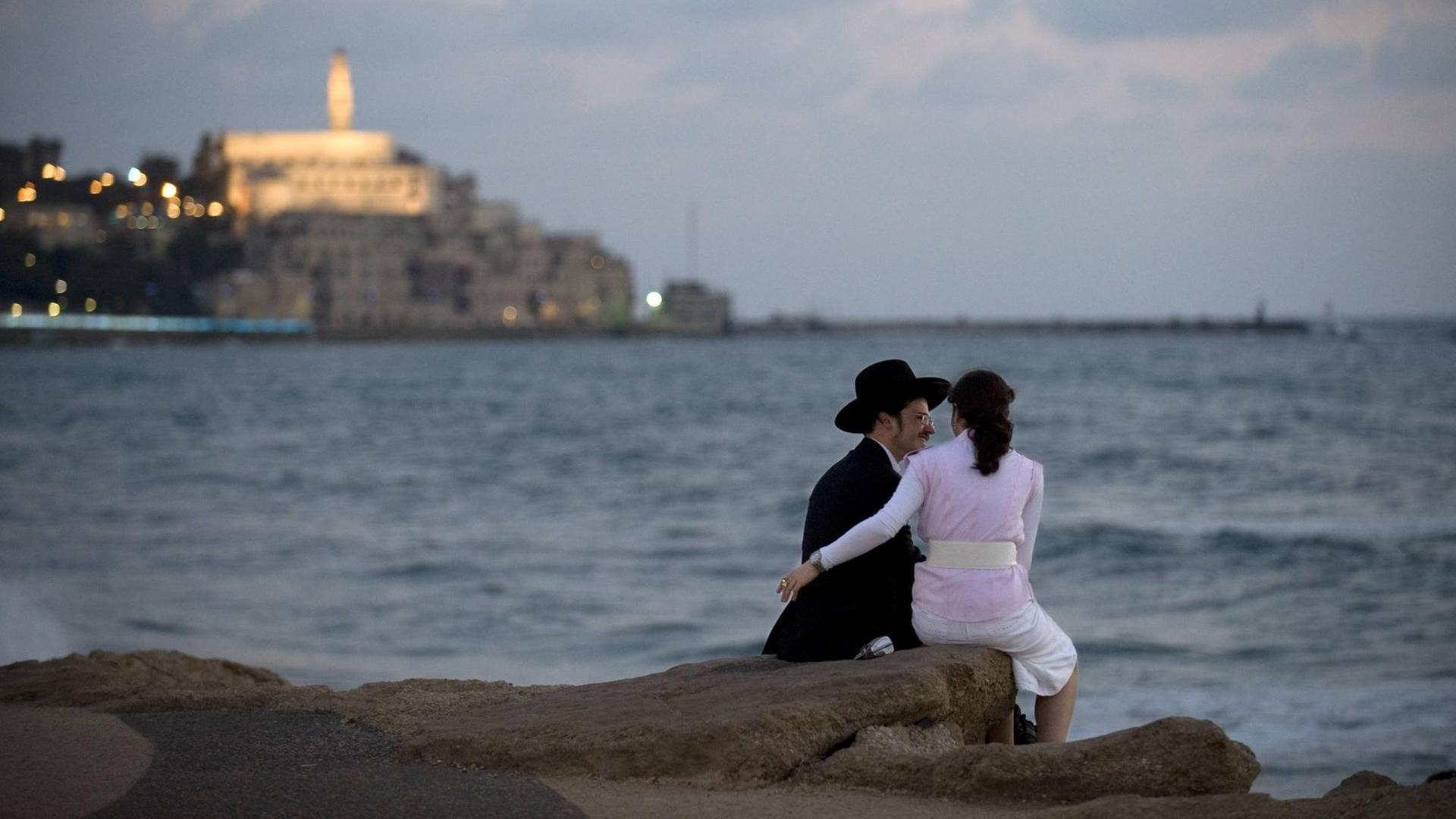 Ein juedisches Paar auf der Promenade am Strand vom Mittelmeer von Tel Aviv. Im Hintergund die Altstadt von Jaffa mit der Kirche St. Peter Church. Ein juedisches Paar auf der Promenade am Strand vom Mittelmeer von Tel Aviv. Im Hintergund die Altstadt von Jaffa mit der Kirche St. Peter Church.