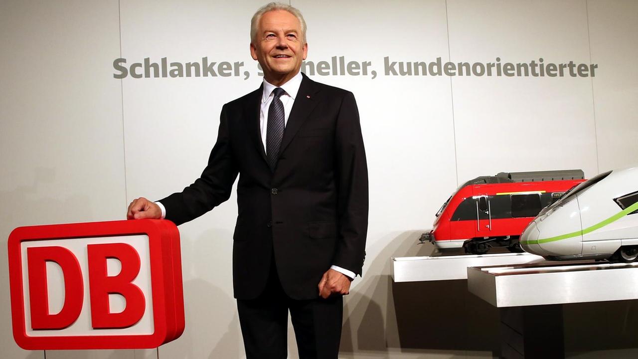 Bahnchef Rüdiger Grube posiert zu Beginn der Halbjahres-Pk für die Fotografen. Er hält die Hand auf ein Bahn-Logo. Neben ihm sind zwei große Modellbahnen zu sehen. Bahnchef Rüdiger Grube posiert zu Beginn der Halbjahres-Pk für die Fotografen. Er hält die Hand auf ein Bahn-Logo. Neben ihm sind zwei große Modellbahnen zu sehen.