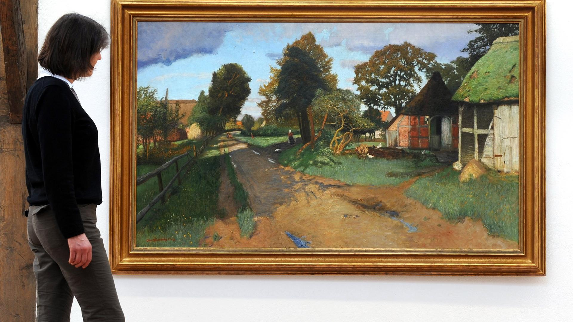 Antje Modersohn, Enkelin des Worpsweder Malers Otto Modersohn, vor dem Gemälde "Dorfstraße in Worpswede". Antje Modersohn, Enkelin des Worpsweder Malers Otto Modersohn, vor dem Gemälde "Dorfstraße in Worpswede".
