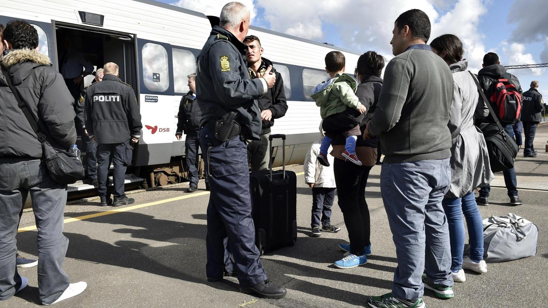 Dänische Polizisten hindern Flüchtlinge auf einem Bahnhof an der Weiterreise nach Schweden. Dänische Polizisten hindern Flüchtlinge auf einem Bahnhof an der Weiterreise nach Schweden.