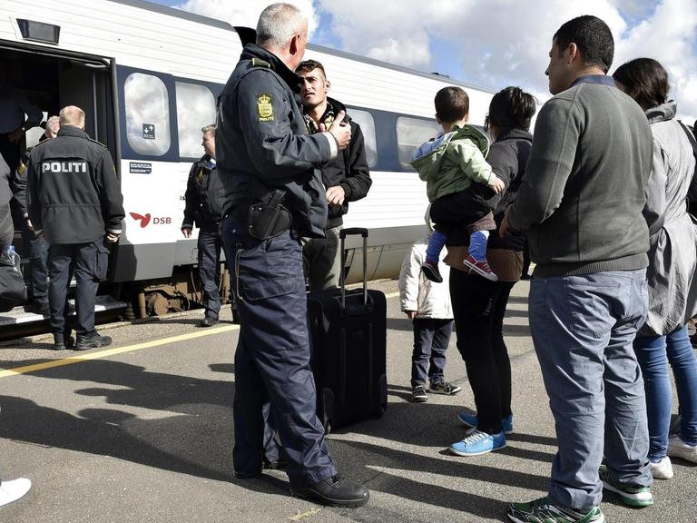 Dänische Polizisten hindern Flüchtlinge auf einem Bahnhof an der Weiterreise nach Schweden.