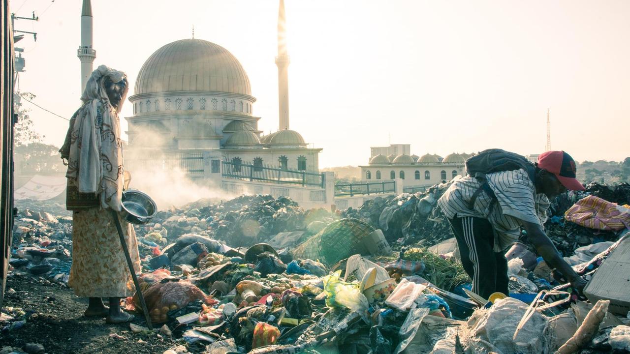 Conakry: Armut trotz Ressourcenreichtum. Menschen suchen im Abfall nach Verwertbarem. Im Hintergrund eine Moschee. Conakry: Armut trotz Ressourcenreichtum. Menschen suchen im Abfall nach Verwertbarem. Im Hintergrund eine Moschee.