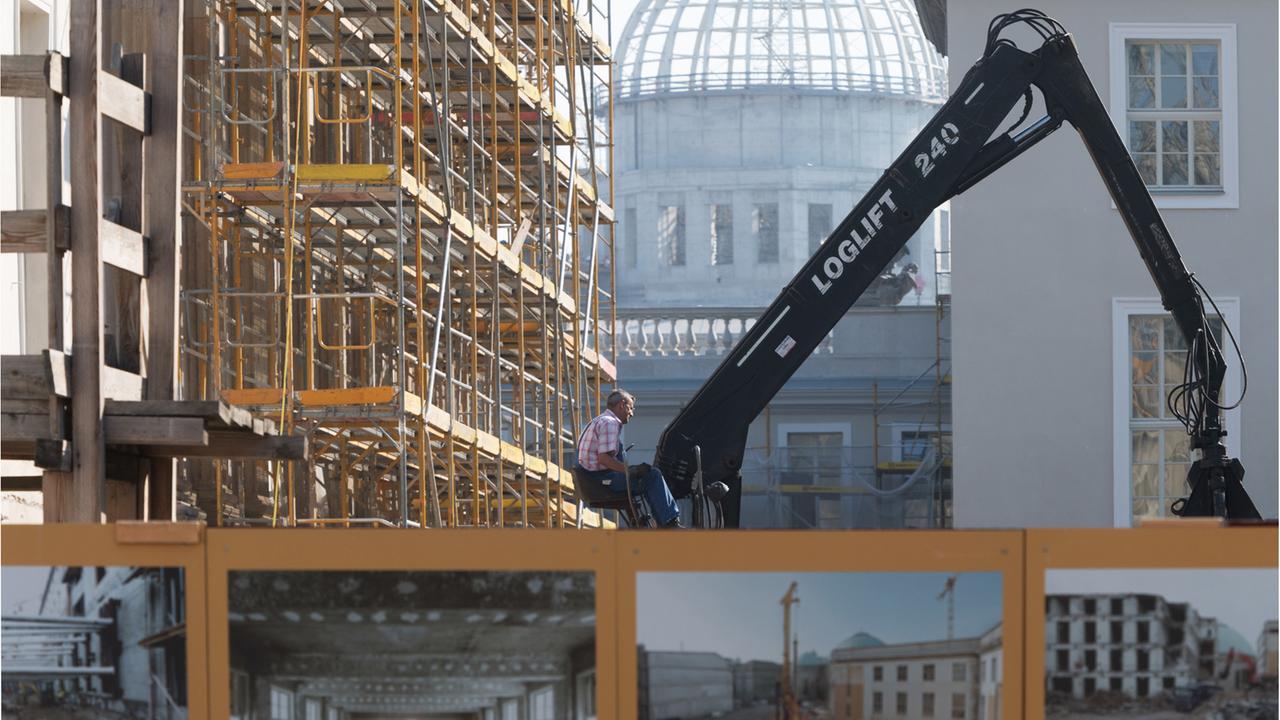 Ein Arbeiter sitzt am 13.9.2016 in Berlin vor der Kulisse der Kuppel des Stadtschlosses neben dem Baugerüst an der Staatsoper Unter den Linden. Ein Arbeiter sitzt am 13.9.2016 in Berlin vor der Kulisse der Kuppel des Stadtschlosses neben dem Baugerüst an der Staatsoper Unter den Linden.