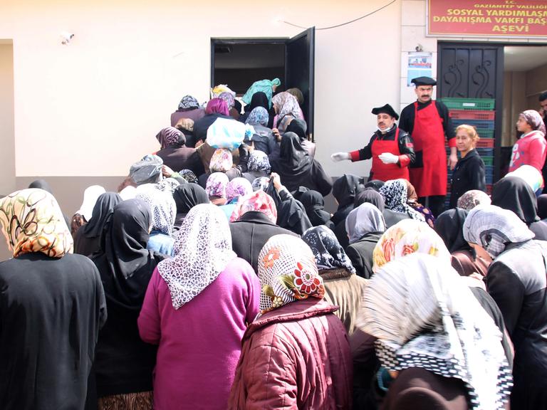 Syrische Frauen, die übrigens nach den Männern dran waren, warten am 04.03.2015 vor der Essensausgabe im Flüchtlingslager im türkischen Gaziantep. Die Syrer in der Türkei sind dem Bürgerkrieg entkommen, und ihr Gastland versucht nach Kräften, ihnen zu helfen. Trotzdem ist die Lage der Flüchtlinge hoffnungslos. Foto: Can Merey/dpa (Zum Jahrestag des Beginns des Aufstands gegen Assad am 15. März - zu dpa "Syrer in der Türkei: «Ich erwarte, dass ich hier sterben werde»" am 09.03.2015)