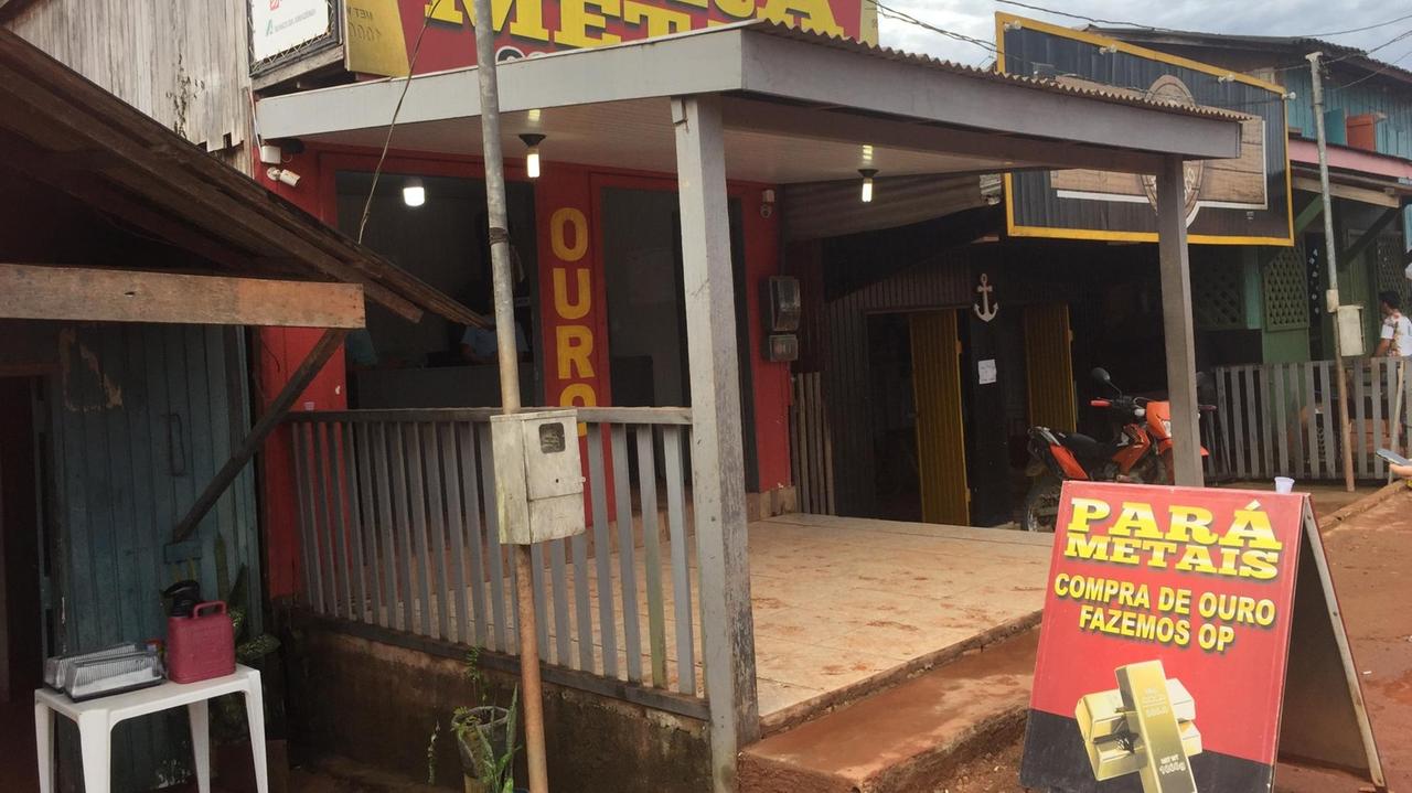 Ein unscheinbarer Laden in Creporizao vor dem ein rotes Plakat mit zwei Goldbarren Werbung für den Goldankauf macht.. Ein unscheinbarer Laden in Creporizao vor dem ein rotes Plakat mit zwei Goldbarren Werbung für den Goldankauf macht..