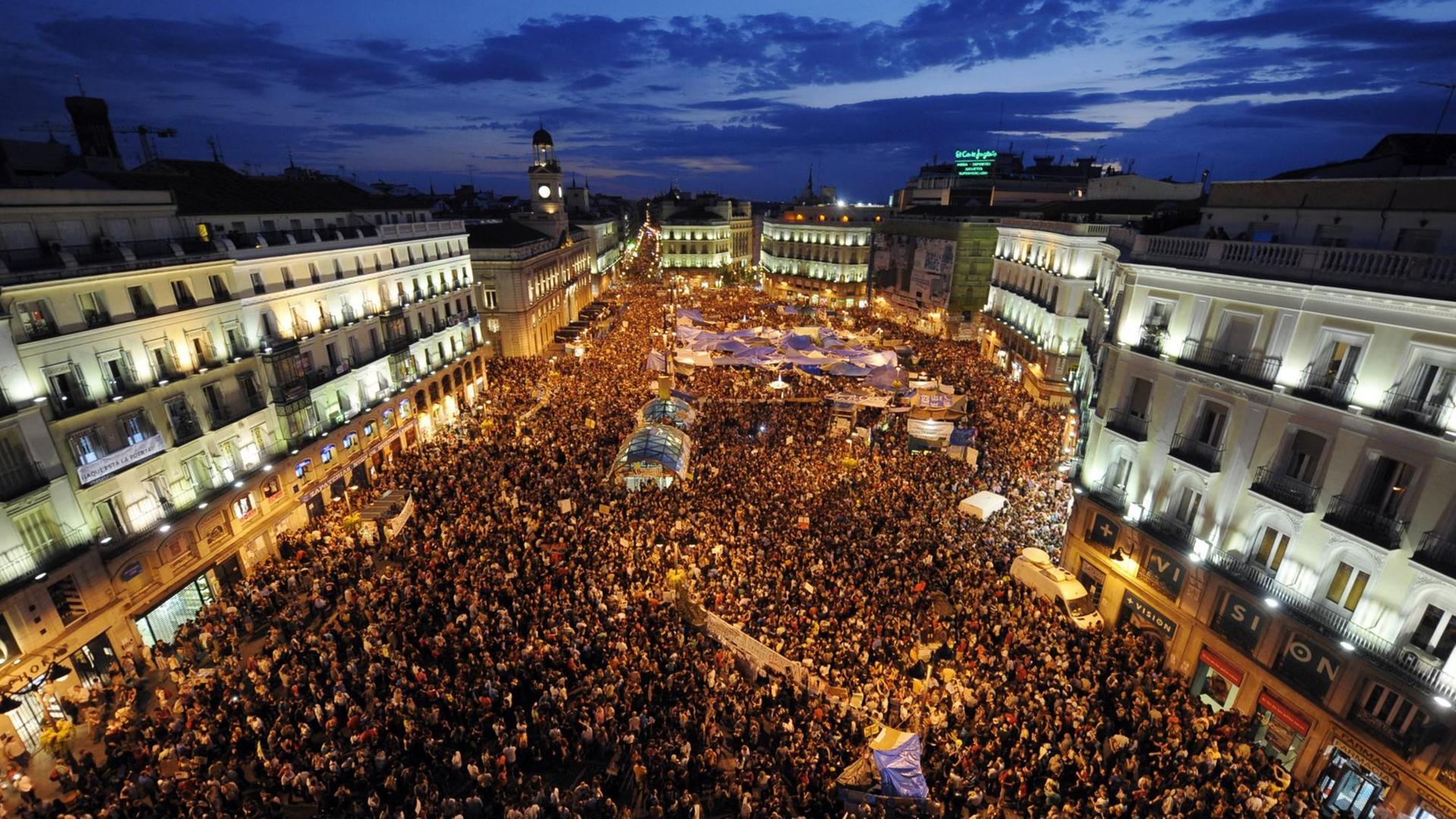 Luftaufnahme vom zentralen Platz Puerta del Sol in Madrid mit Zehntausenden Demonstranten während der Dämmerung. Luftaufnahme vom zentralen Platz Puerta del Sol in Madrid mit Zehntausenden Demonstranten während der Dämmerung.