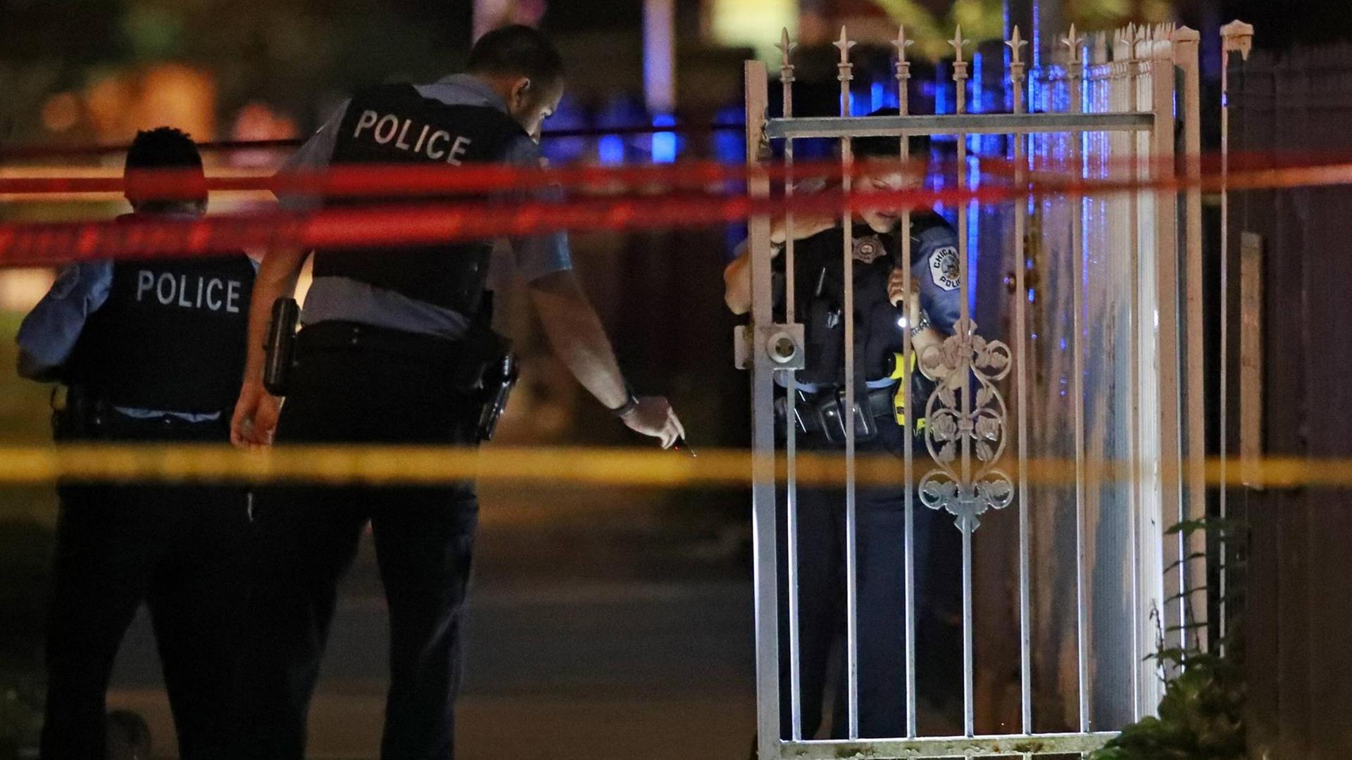 Nächtlicher Einsatz: Polizisten am mit Band abgesperrten Tatort eines Verbrechens in Chicago. Nächtlicher Einsatz: Polizisten am mit Band abgesperrten Tatort eines Verbrechens in Chicago.