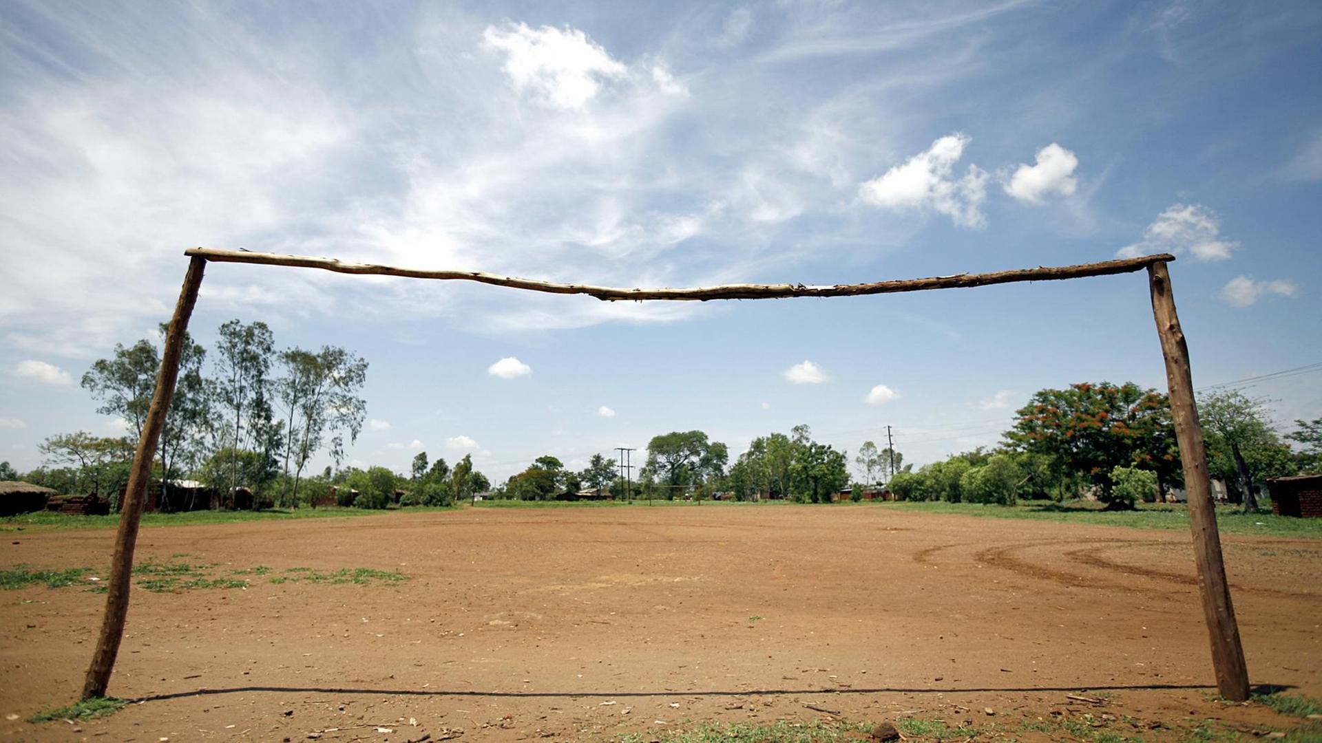 Der Fußballplatz eines Dorfes ohne nennenswerten Rasen und mit einem roh gezimmerten Tor ohne Netz aus Baumstämmen, aufgenommen am 2006 nahe der Stadt Blantyre (Provinz Mphuka) in Malawi. Der Fußballplatz eines Dorfes ohne nennenswerten Rasen und mit einem roh gezimmerten Tor ohne Netz aus Baumstämmen, aufgenommen am 2006 nahe der Stadt Blantyre (Provinz Mphuka) in Malawi.