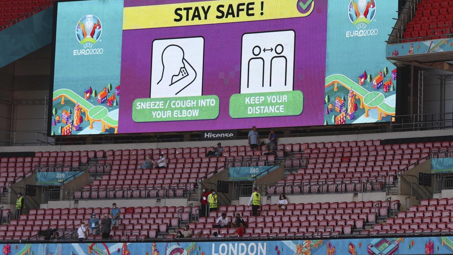 Hygienehinweise stehen vor einem EM-Gruppenspiel auf einer Videoleinwand im Londoner Wembley-Stadion.