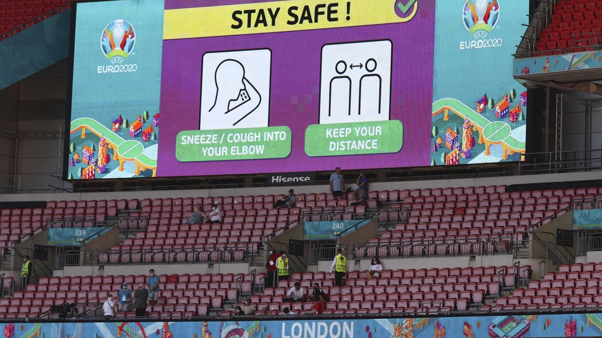 Hygienehinweise stehen vor einem EM-Gruppenspiel auf einer Videoleinwand im Londoner Wembley-Stadion. Hygienehinweise stehen vor einem EM-Gruppenspiel auf einer Videoleinwand im Londoner Wembley-Stadion.