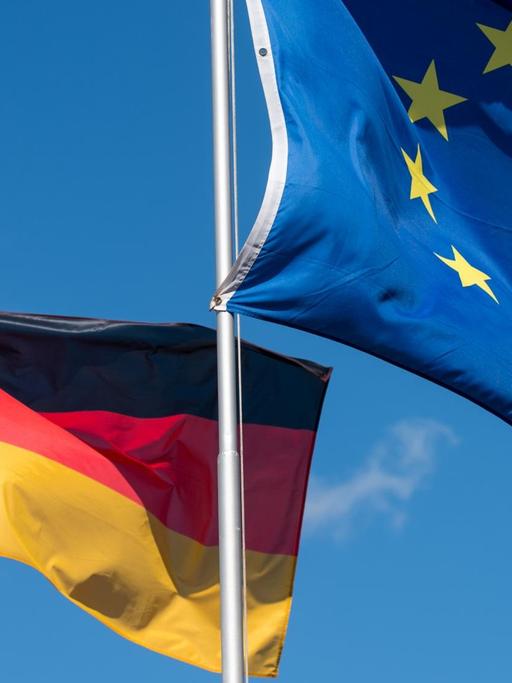 Die Nationalfahne von Deutschland und die Flagge der Europäischen Union wehen im Wind