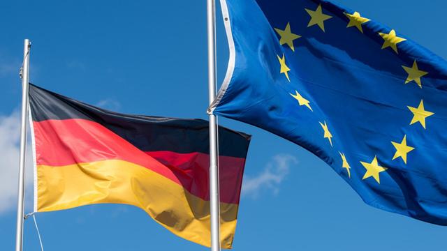 Die Nationalfahne von Deutschland und die Flagge der Europäischen Union wehen im Wind
